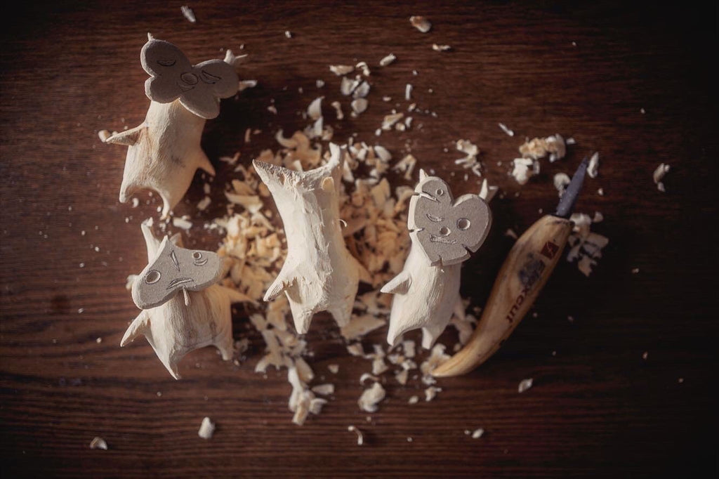 Wooden Korok figurines on a wooden surface with a knife