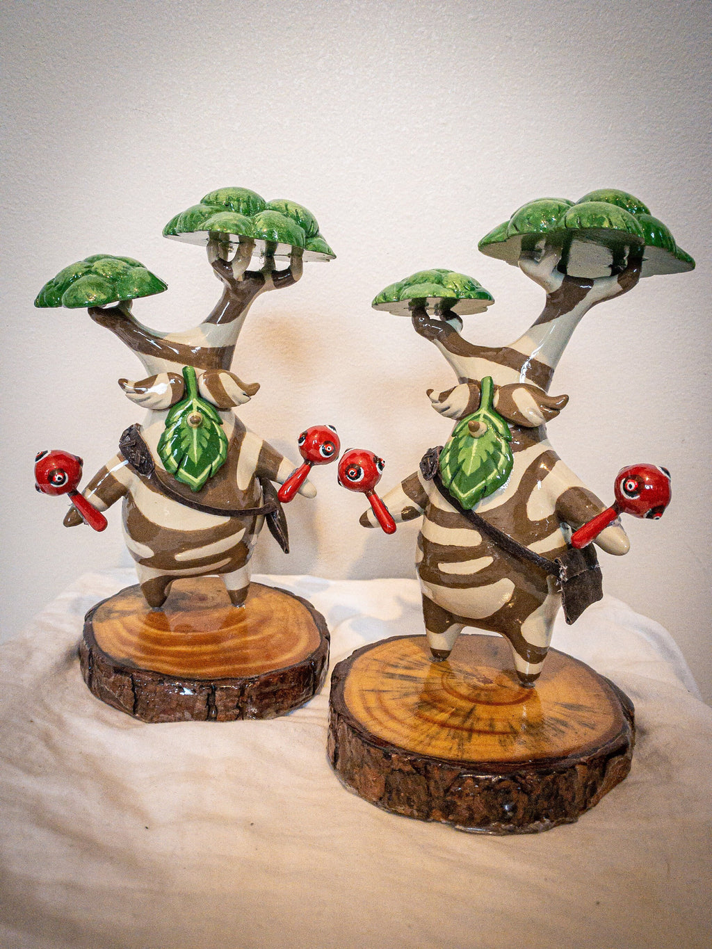 Two decorative figurines with tree-like structures on a neutral background