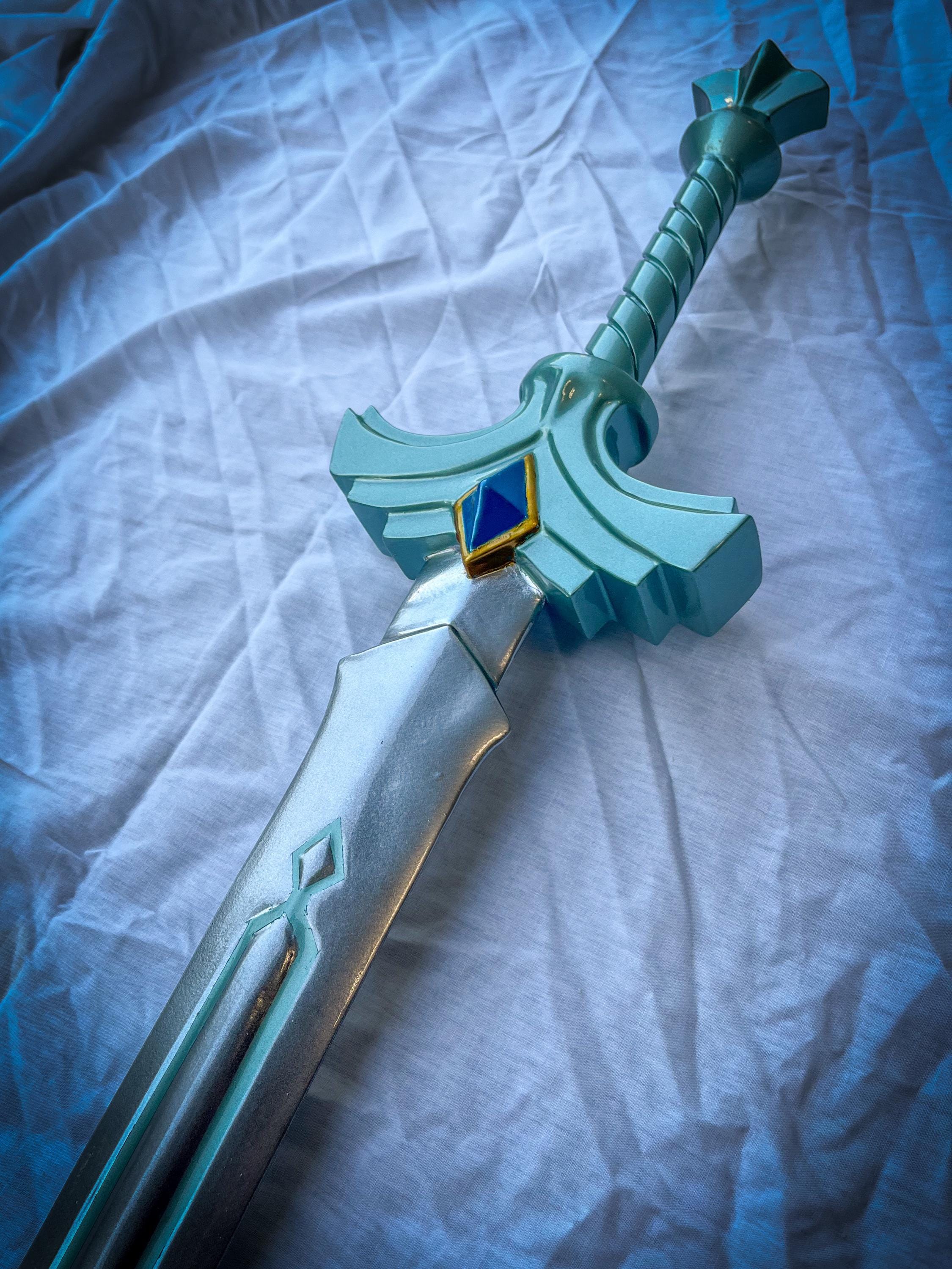 Turquoise sword with a blue gem on a white fabric background