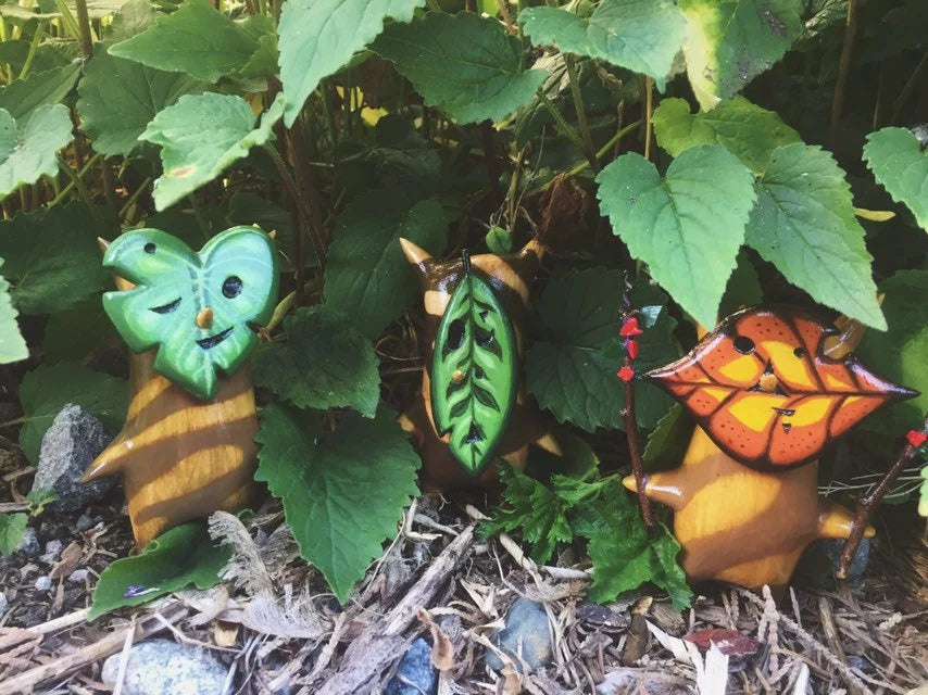 Korok wooden figurines among green leaves and garden elements
