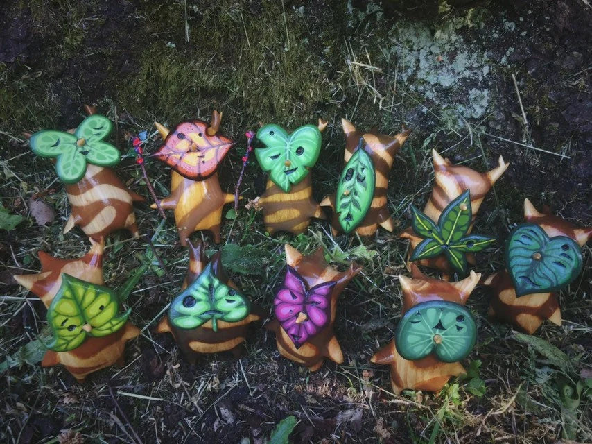 Colorful leaf-shaped korok statues on a dark background