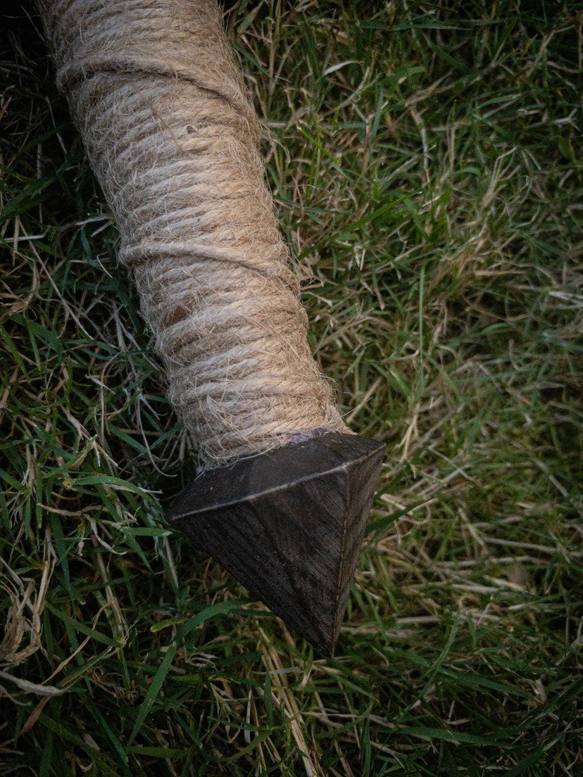 Handle and pommel of the wooden kokpri sword against grassy background