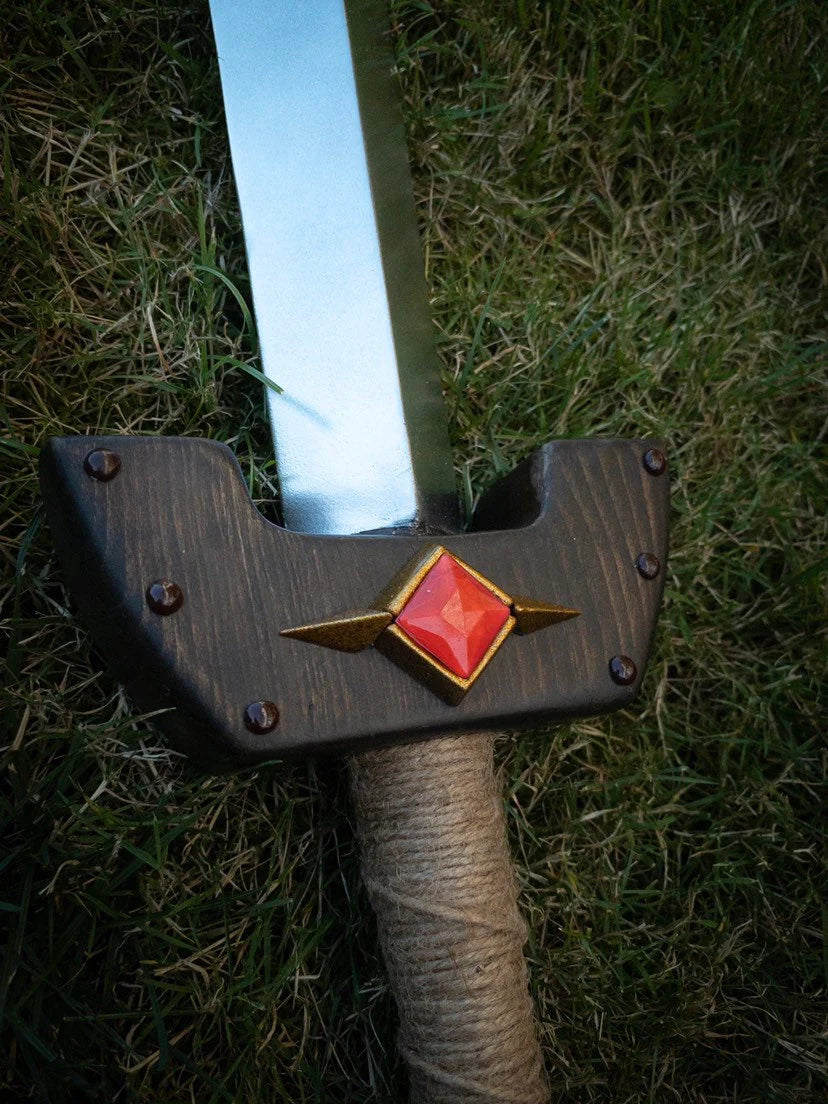 Wooden Kokiri Sword with decorative hilt on grass