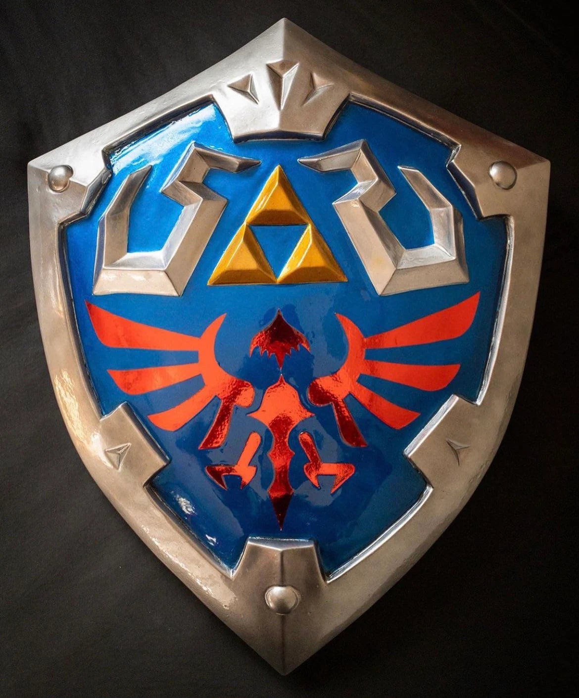 Shield with Triforce symbol on a dark background