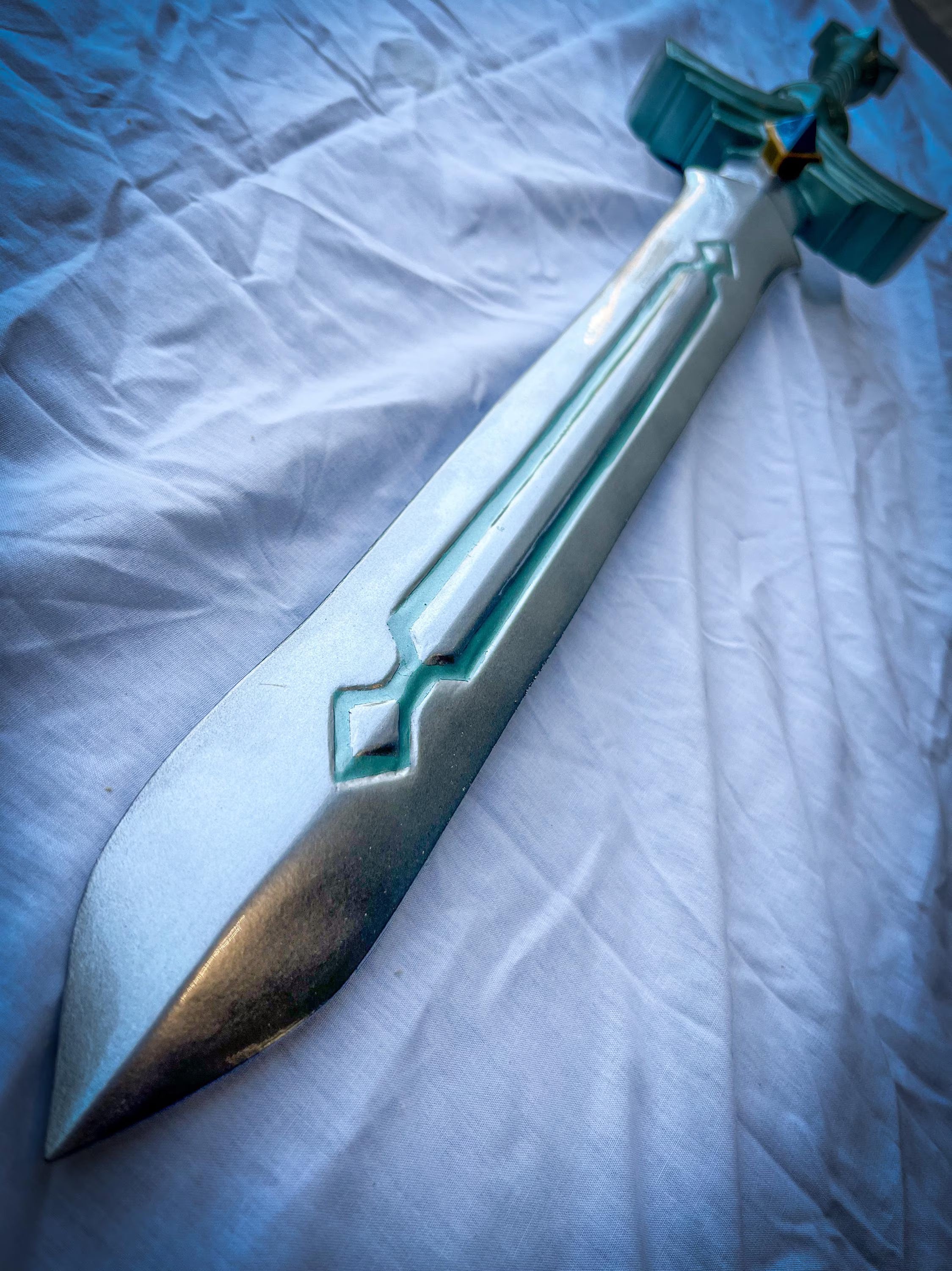 Sword with decorative handle on a textured white surface